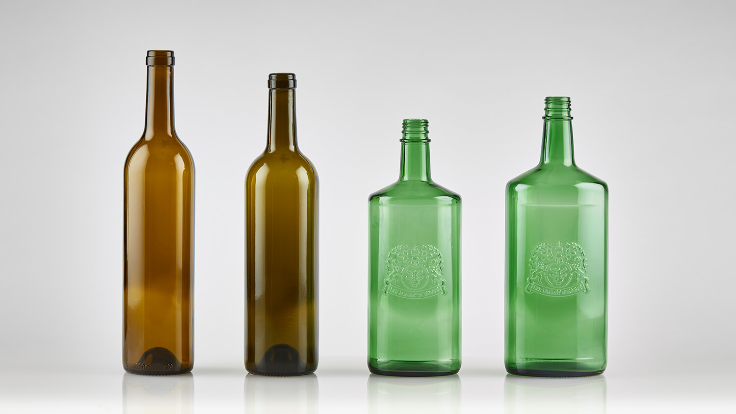 Custom embossed logos on wine and sake bottles in diverse shapes.