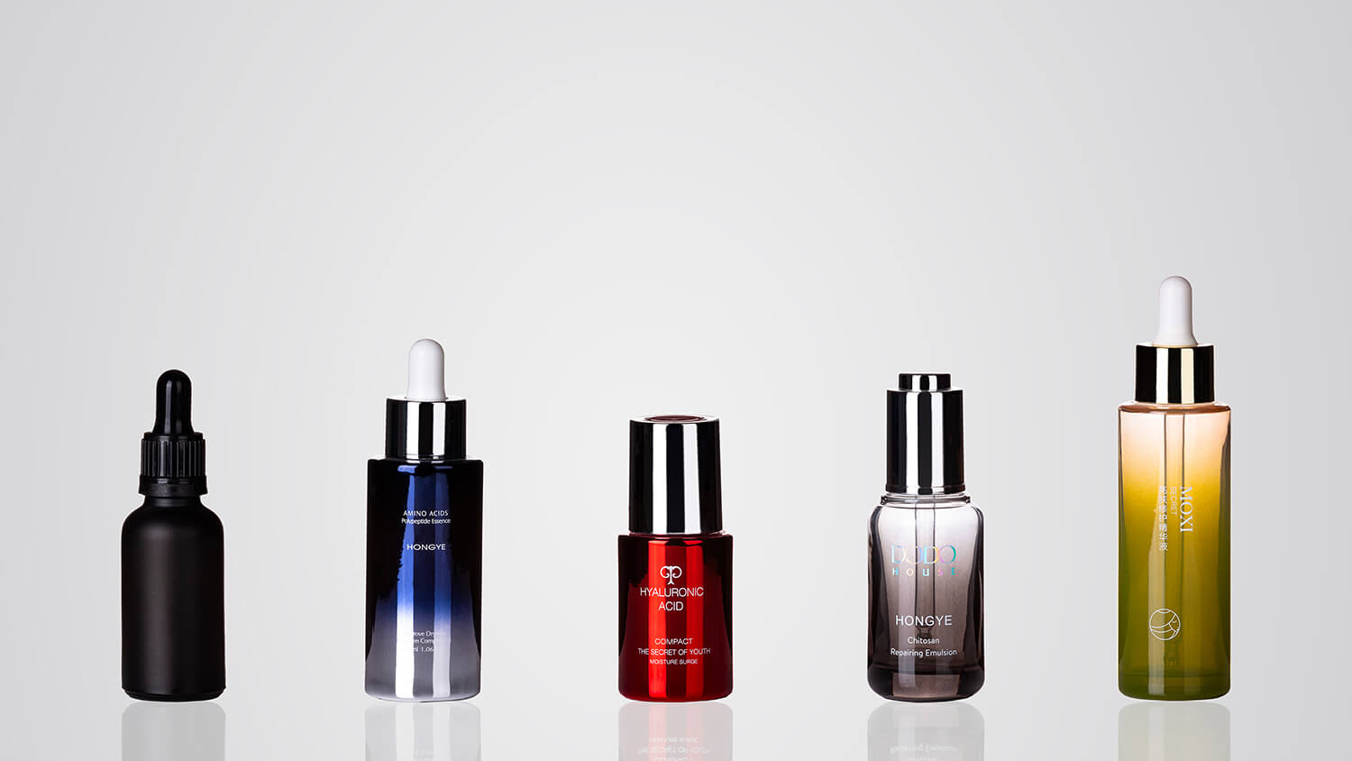 Decorated dropper bottles featuring custom graphics and finishes, ideal for serums and beauty formulas.
