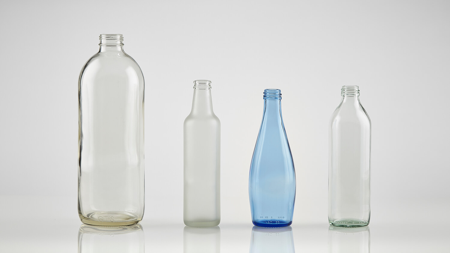 Clear and blue beverage bottles in varied styles, textures, and mold designs.
