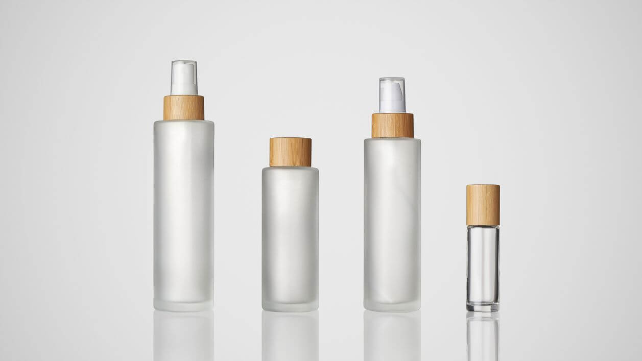 Bamboo glass bottles with sprayers combining natural and modern design.