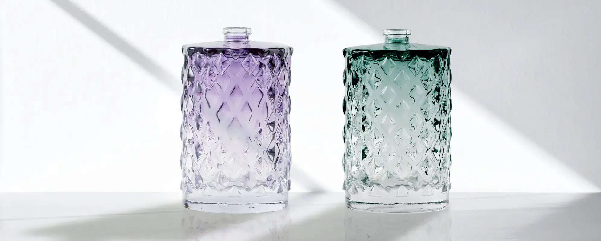 Color sprayed perfume bottles, with a clean pink and green gradient.