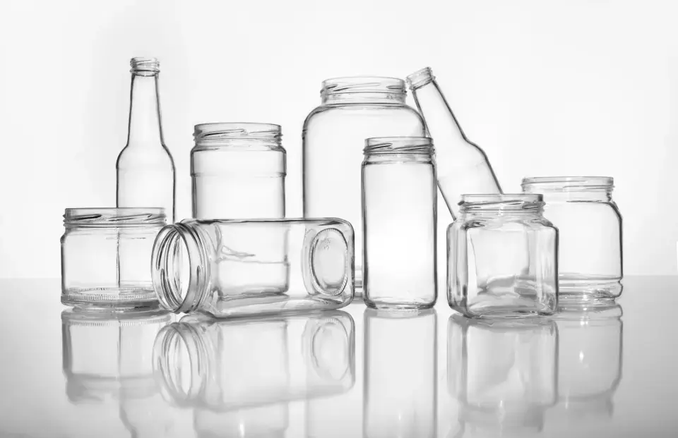 A variety of glass bottles and jars together.