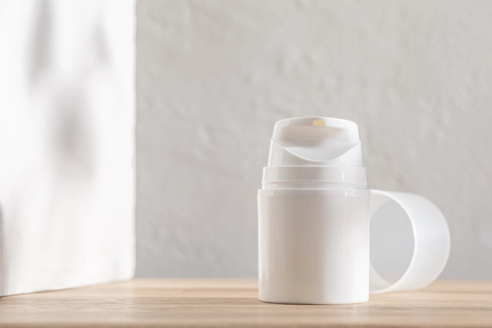 Airless pump on table, with textured background.