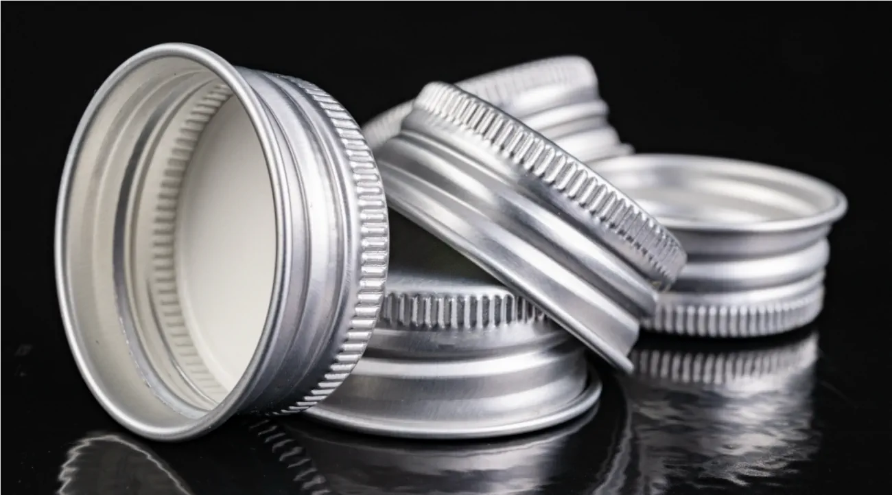 Multiple silver metal caps lying next to each other.