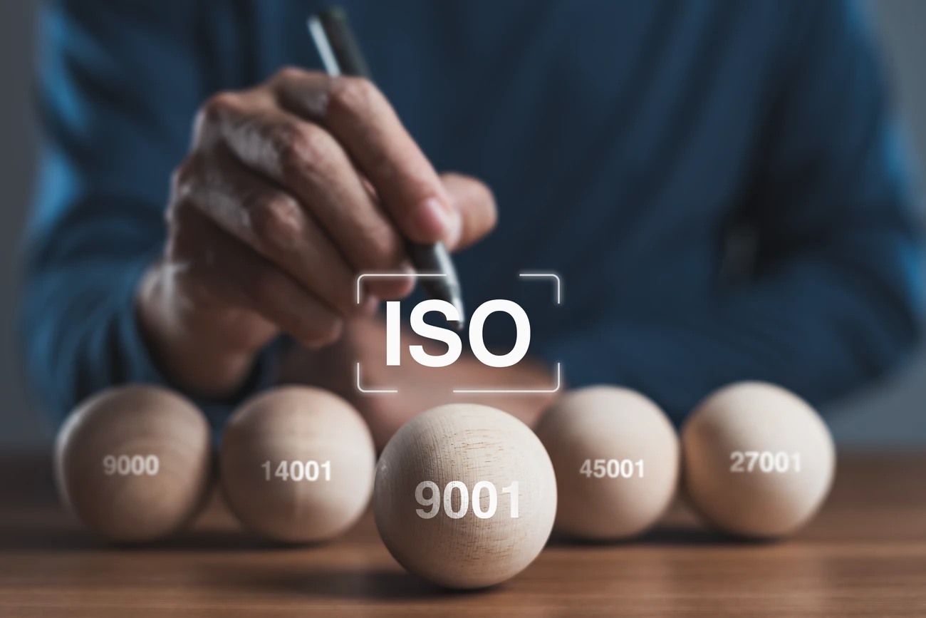 ISO Certifications on balls in front of a man with a pencil.