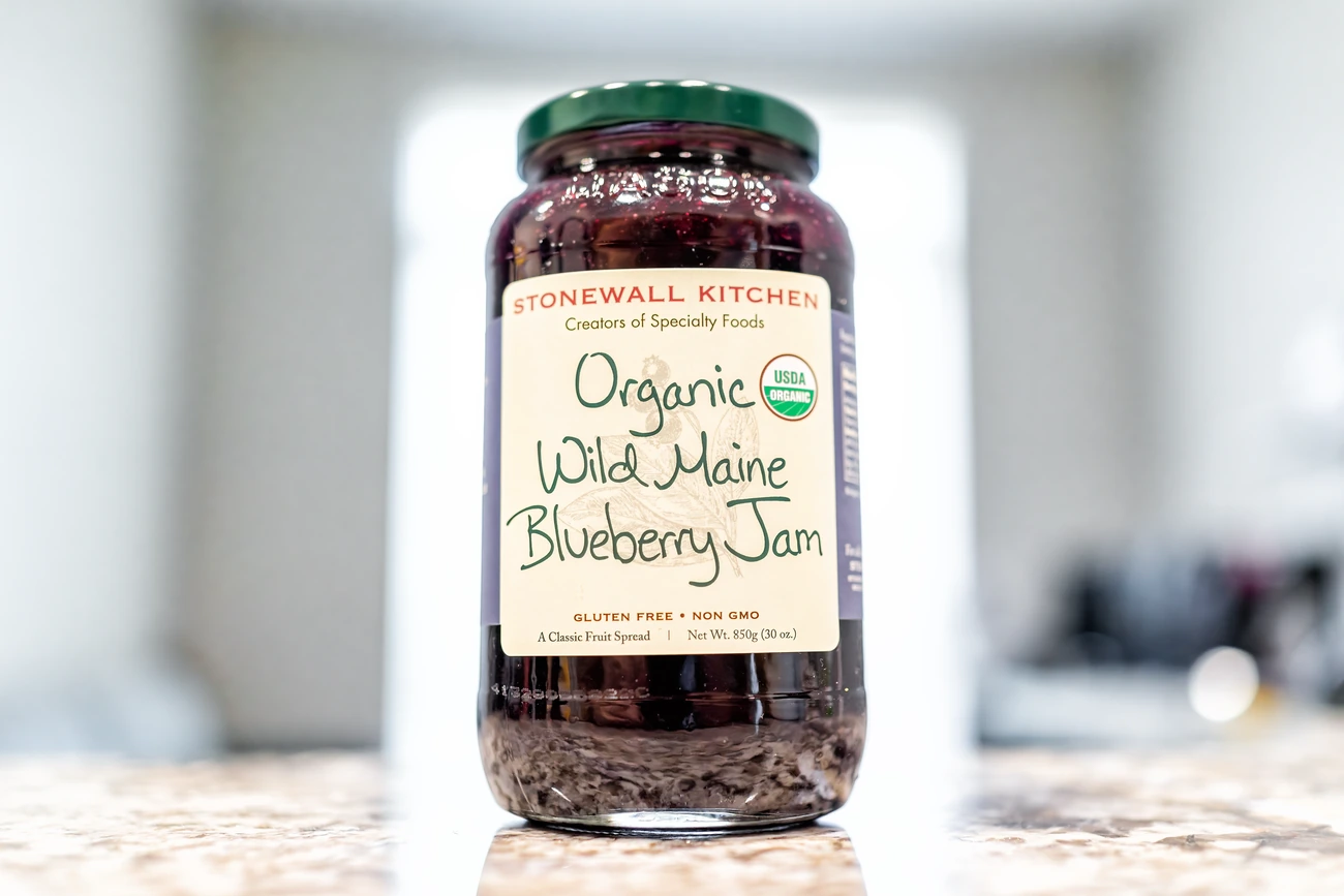 Wild berry jam jar, with clean labeling on a table.