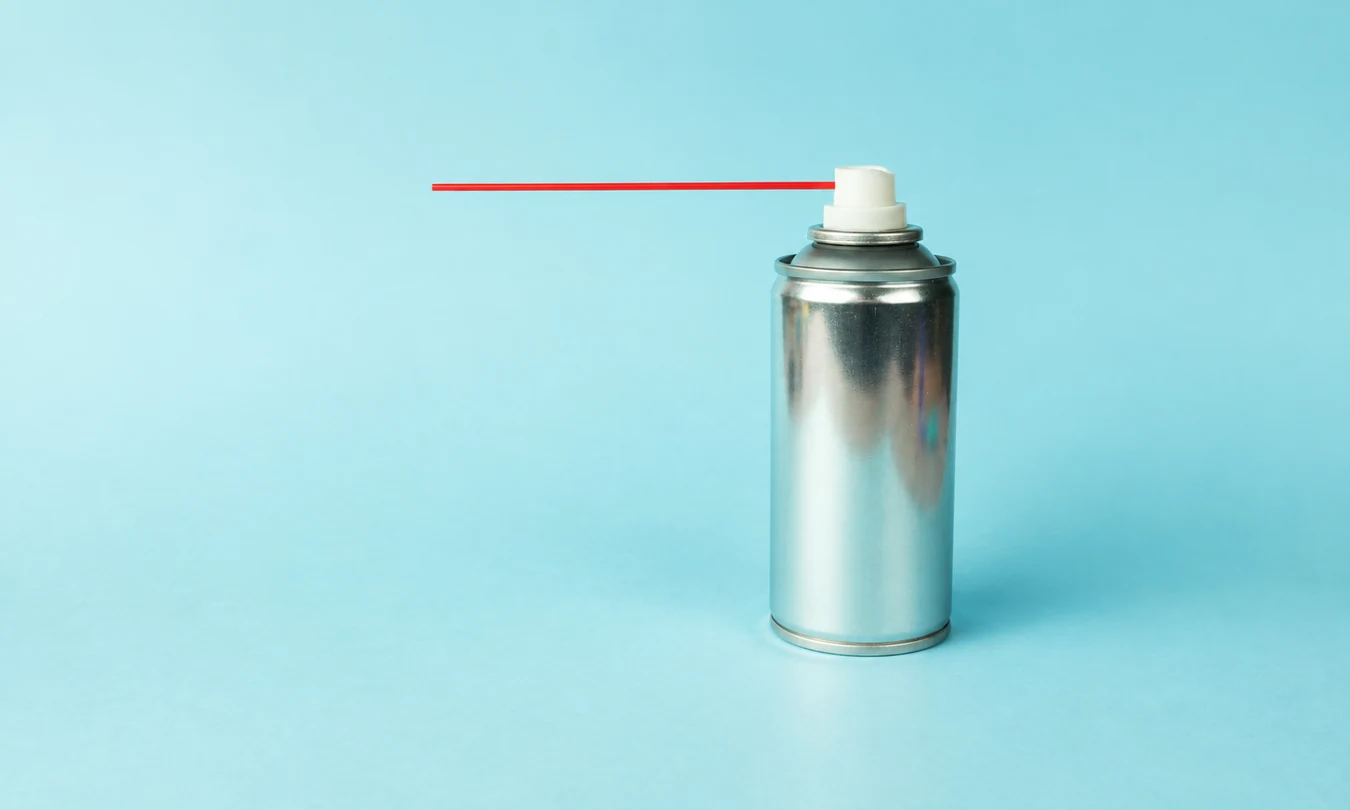common-metal-packaging-formats-hero Silver metal aerosol can with an actuator, in front of a light blue background.