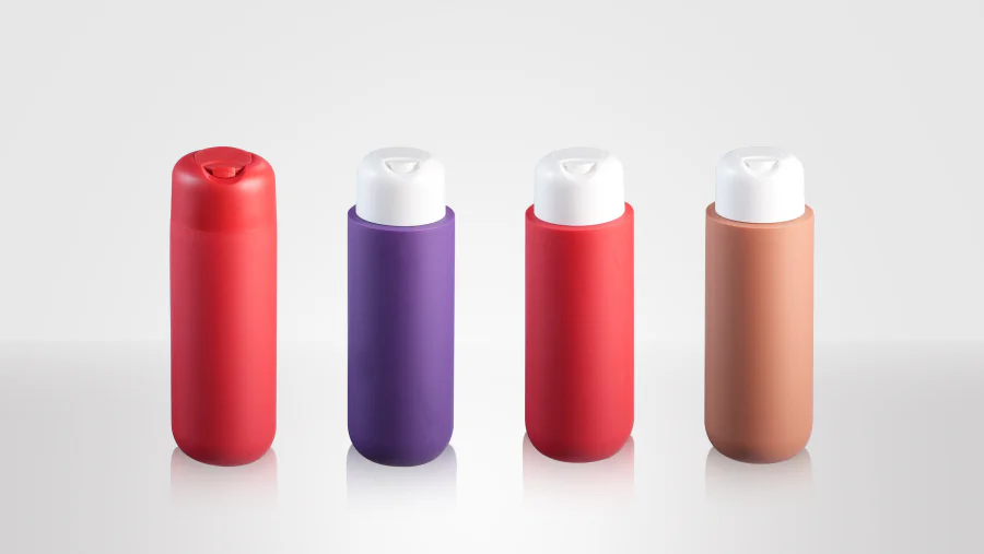 Tamper-evident disc top closures on rounded red, purple, coral-red, and tan plastic bottles, including matching red and contrasting white dispensing caps.
