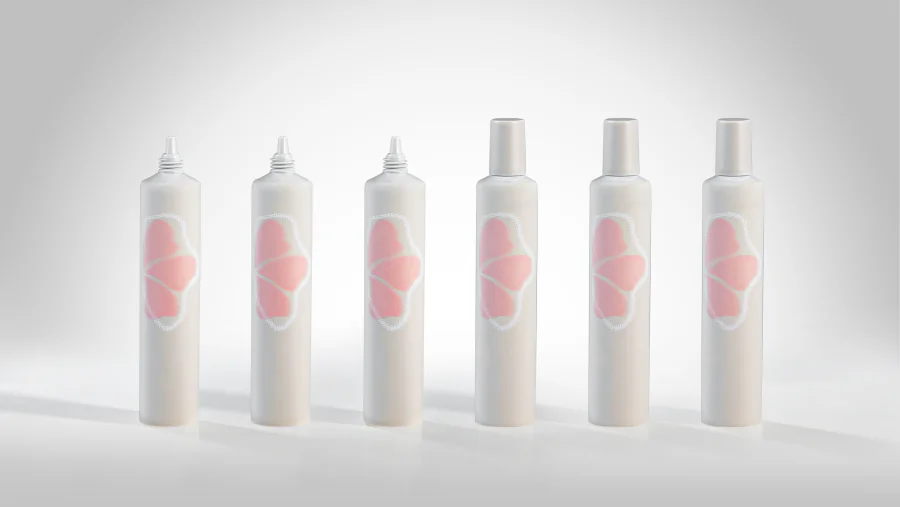 Slim white five-layer PE squeeze tubes with a soft velvet-texture finish and pink printed graphics, shown with narrow applicator nozzles exposed and matching caps attached.
